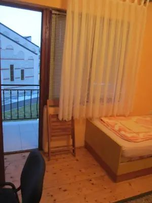 a bedroom with a bed and a window with a balcony at Bravo Guest House in Bihać