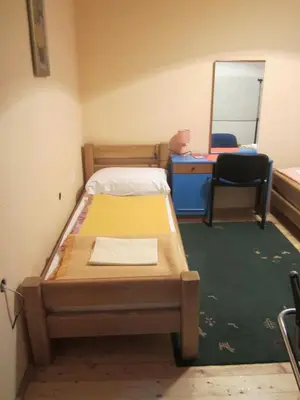a bedroom with a bed and a desk and a mirror at Bravo Guest House in Bihać