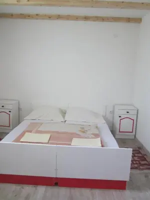 a white bed in a room with two night stands at Bravo Guest House in Bihać