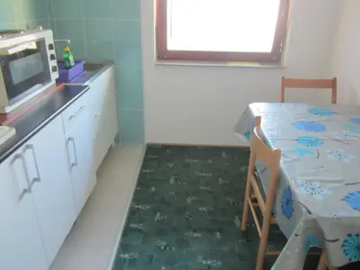 a small kitchen with a table and a microwave at Bravo Guest House in Bihać