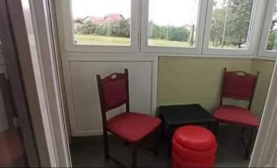 two chairs and a table in a room with windows at Sofi in Rebrovac