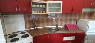 a kitchen with a sink and a stove and red cabinets at Sofi in Rebrovac