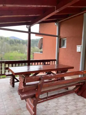 a wooden picnic table on a balcony with a view at Vikendica Krivaja sa bazenom i privatnom plažom in Zavidovići