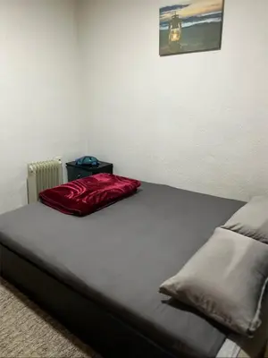 a bed with a red pillow on top of it at Vikendica Krivaja sa bazenom i privatnom plažom in Zavidovići