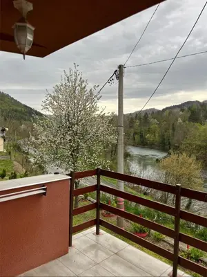 a balcony with a view of a river at Vikendica Krivaja sa bazenom i privatnom plažom in Zavidovići
