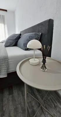 a bedroom with a bed with a table in front of it at Apartman STARI GRAD in Bihać