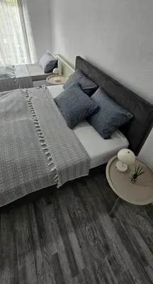 a bedroom with a large bed and a table at Apartman STARI GRAD in Bihać