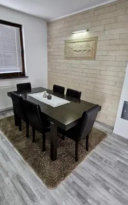 a dining room with a black table and black chairs at Apartman STARI GRAD in Bihać
