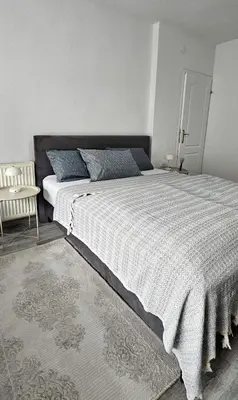 a bedroom with a large bed and a chair at Apartman STARI GRAD in Bihać