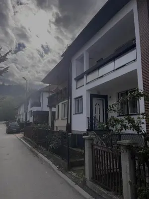a white house with a fence next to a street at Vacation Home Maja in Visoko