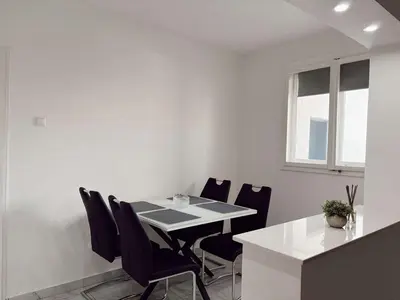 a white dining room with a table and chairs at Vacation Home Maja in Visoko