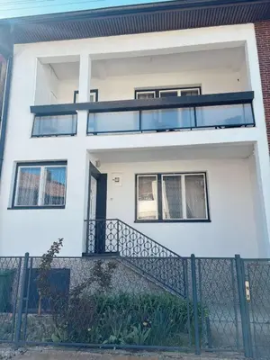 a white house with a balcony and a fence at Vacation Home Maja in Visoko