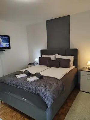 a bedroom with a large bed with two books on it at Lena Exclusive in Bihać