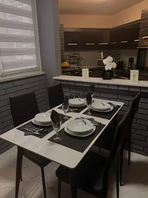 a table with plates and glasses on it in a kitchen at Lena Exclusive in Bihać