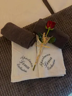 two towels with a rose on top of a bed at Lena Exclusive in Bihać