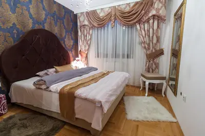 a bedroom with a large bed and a window at Apartment Barby - Deluxe in Banja Luka