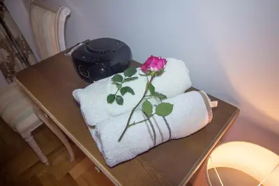 a table with towels and a rose on top at Apartment Barby - Deluxe in Banja Luka