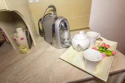 a counter with a tea kettle and cups on a tray at Apartment Barby - Deluxe in Banja Luka