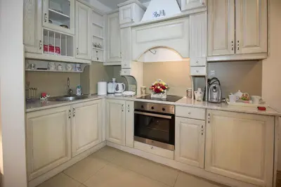 a white kitchen with white cabinets and an oven at Apartment Barby - Deluxe in Banja Luka