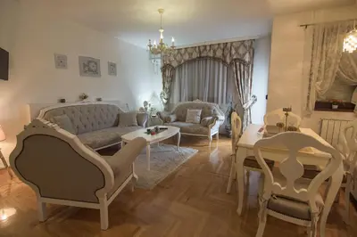 a living room with a couch and a table and chairs at Apartment Barby - Deluxe in Banja Luka