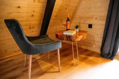 a table with a chair and a bottle of wine at Cottage NIKA2 in Jajce