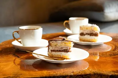two plates of cake and cups of coffee on a table at Cottage NIKA2 in Jajce