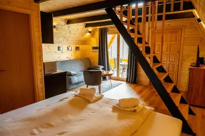a living room with a staircase in a log cabin at Cottage NIKA2 in Jajce