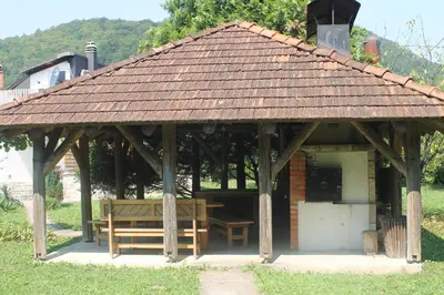 a gazebo with a bench and a table at The River House in Lohovo