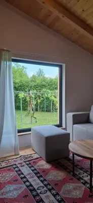 a living room with a couch and a large window at The River House in Lohovo