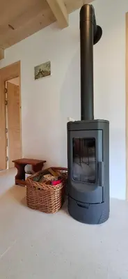 a stove sitting in a living room with a basket at The River House in Lohovo
