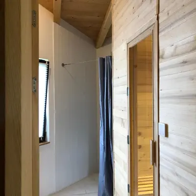 a bathroom with a wooden wall and a door at The River House in Lohovo