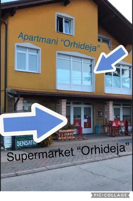 a sign in front of a building with arrows at Studio Apartman Orhideja in Sanski most