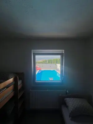 a bedroom with a window with a swimming pool in it at Melissa luxury Apartment in Bijelo Brdo