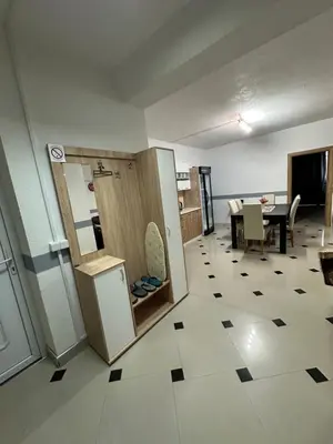 a room with a kitchen and a table with a refrigerator at Apartman Orhideja za 4 osobe in Sanski most