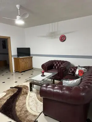 a living room with a leather couch and a coffee table at Apartman Orhideja za 4 osobe in Sanski most