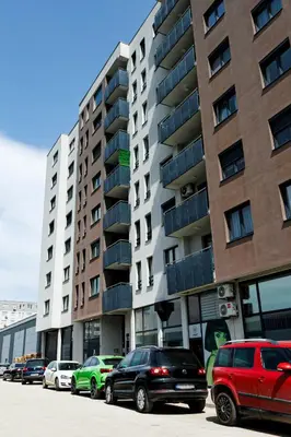 a parking lot with cars parked in front of a building at Apartman Luxury Kiseljak in Kiseljak