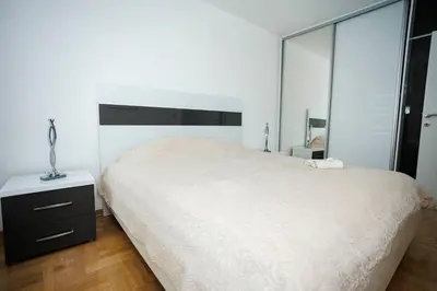 a white bedroom with a large bed and a mirror at Apartman Luxury Kiseljak in Kiseljak