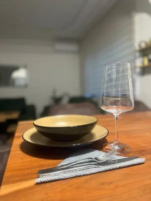 a plate and a glass of wine on a table at Apartman N&N in Bihać
