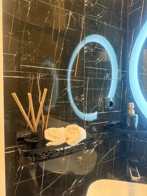 a bathroom with a shelf with towels and a mirror at Apartman N&N in Bihać