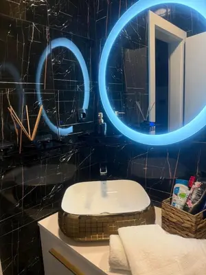 a bathroom with a toilet and a mirror with blue lights at Apartman N&N in Bihać