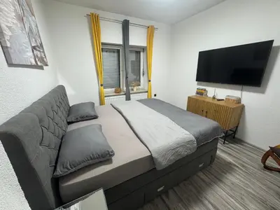 a bedroom with a bed and a flat screen tv at Apartman N&N in Bihać