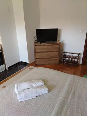 a bedroom with two towels on a bed with a television at Studio D&N in Starčevica