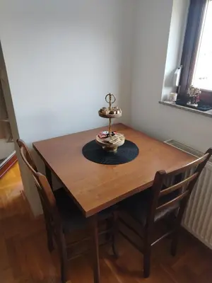 a wooden table with chairs and a cake on top at Studio D&N in Starčevica