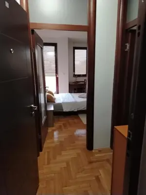 a hallway of a room with a bedroom and a bed at Studio D&N in Starčevica