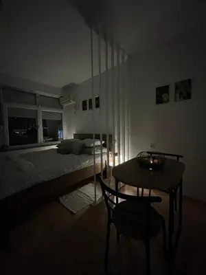 a bedroom with a bed and a table with a chair at Dora Apartman in Banja Luka