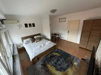 a bedroom with a bed and a table in it at Dora Apartman in Banja Luka