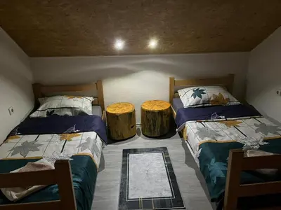 a bedroom with two beds and two tables in it at Apartman Iman in Bihać