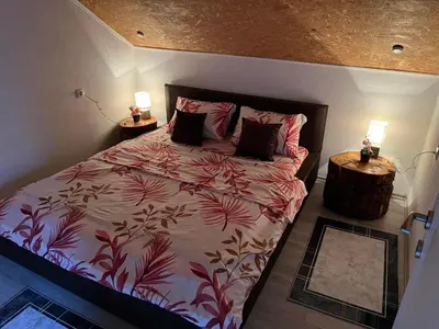 a bedroom with a large bed with two lamps on it at Apartman Iman in Bihać