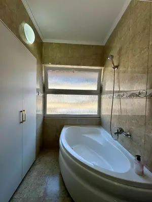 a bathroom with a large tub and a window at Apartman 21 Lux in Banja Luka