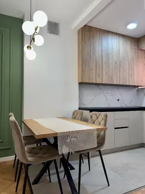 a dining room with a wooden table and chairs at Apartman 21 Lux in Banja Luka